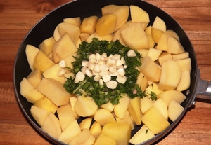 Добавляем в сковородку масло, картошку, укроп и чеснок